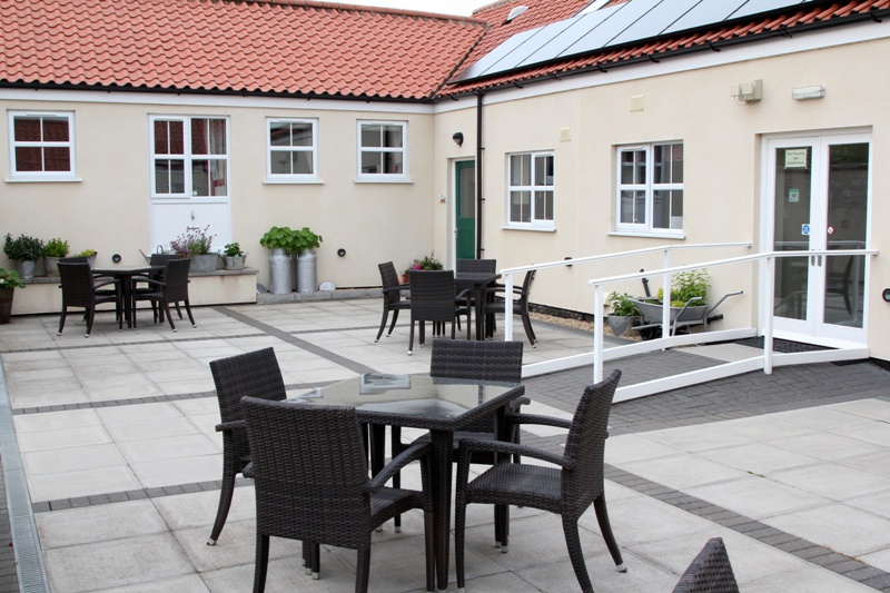 Courtyard patio area with tables and chairs for guests use. This area is a real sun trap